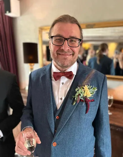 Gent on his wedding day, smiling and dressed formally