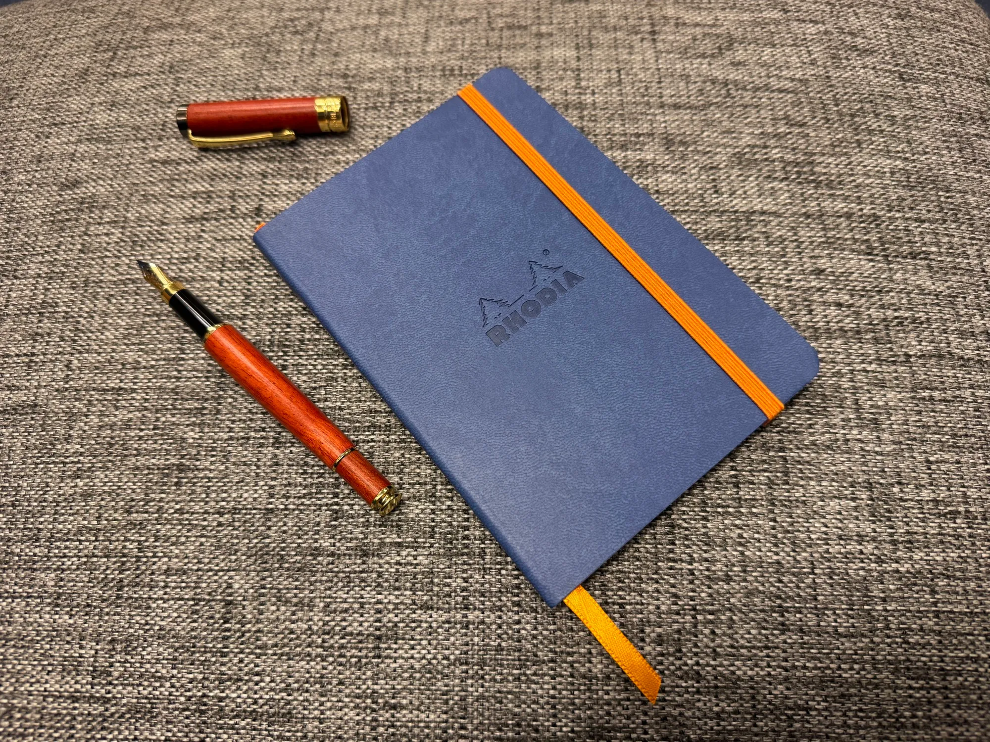 A closed journal with a fountain pen beside it.
